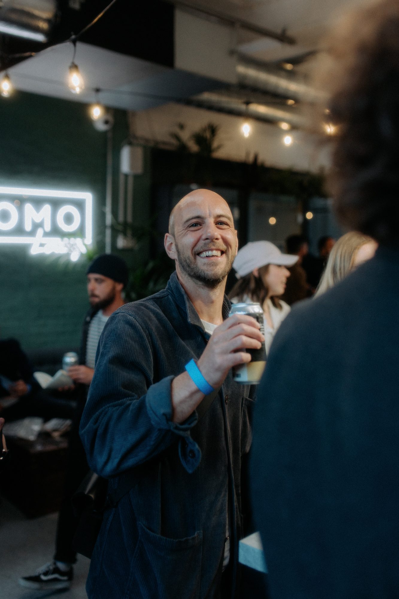 A guest grinning by the FOMO Lounge sign