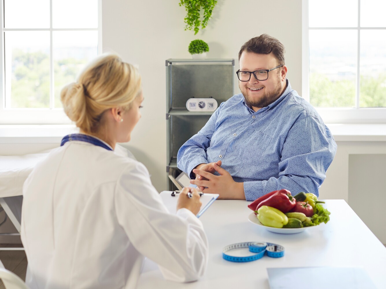 overweight man talking to his dietitian to discuss his weight loss without exercise progress