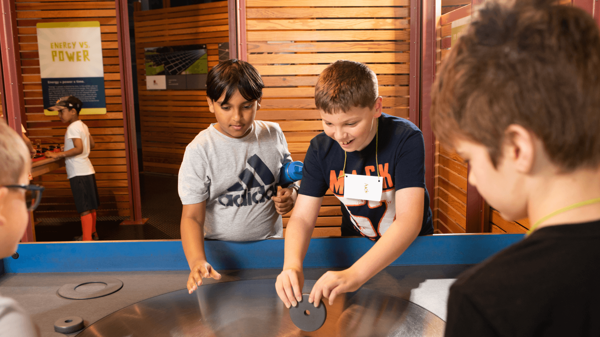 A group of boys work to keep a disc standing the longest.