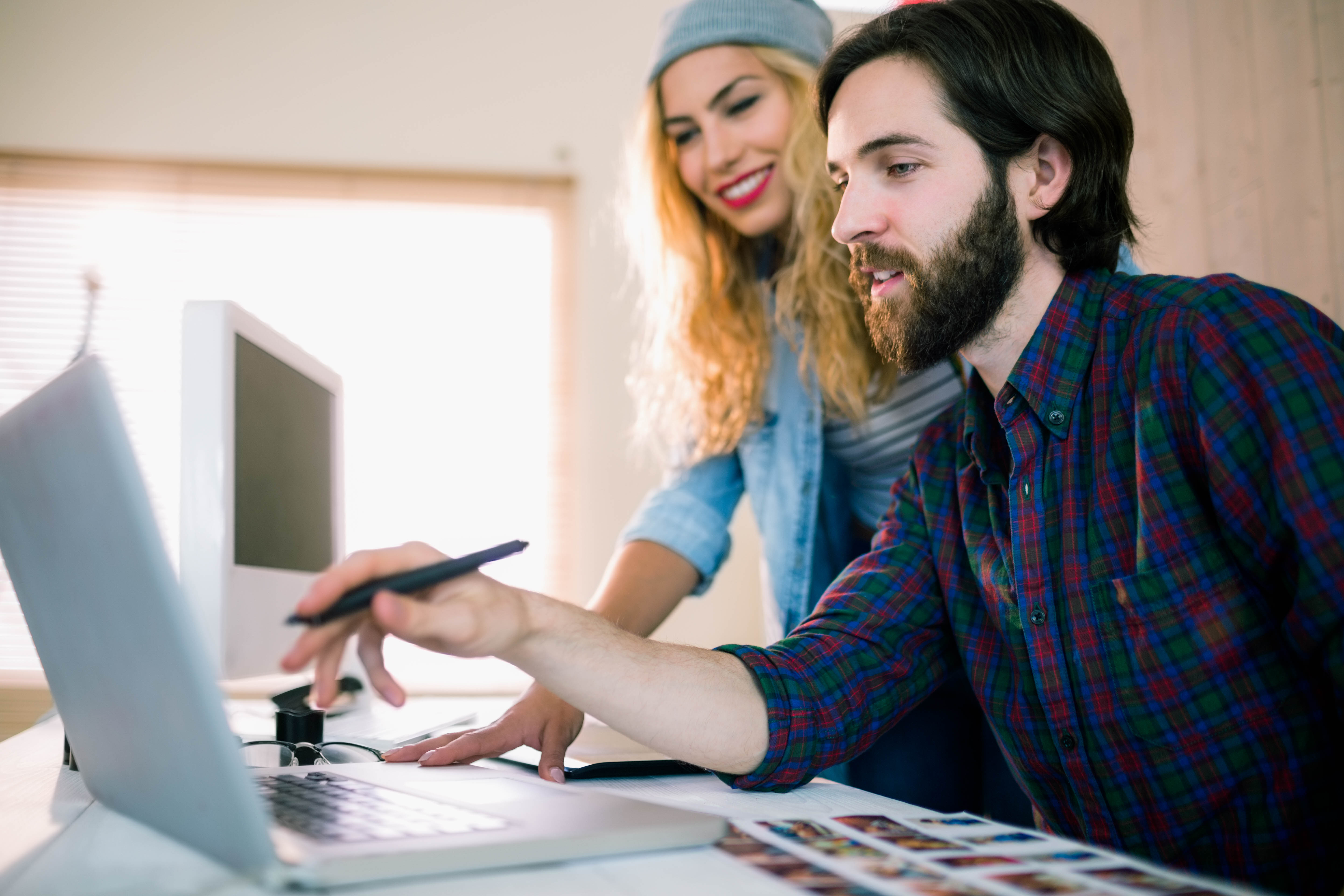 Creative team working on laptop together in casual office