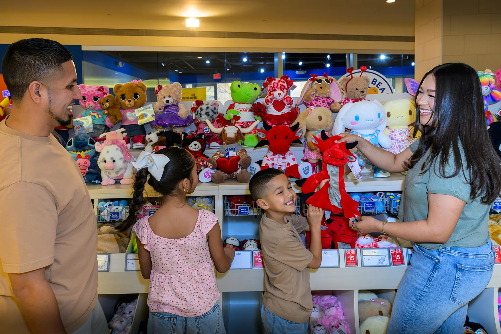 Family choosing stuffed animals together from the plush wall at Build-A-Bear Workshop