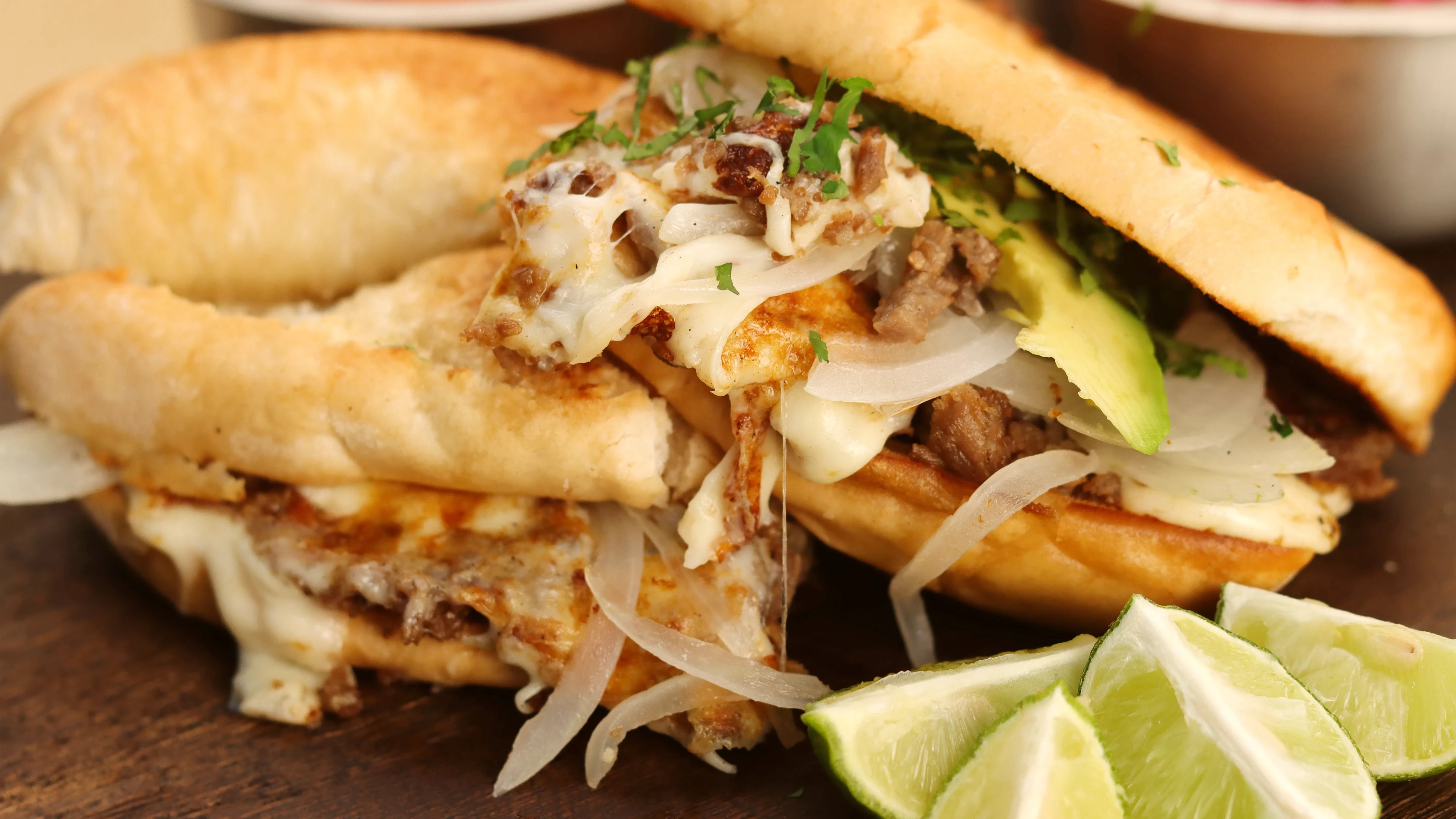 Torta de bistec con aguacate y cebolla asada.