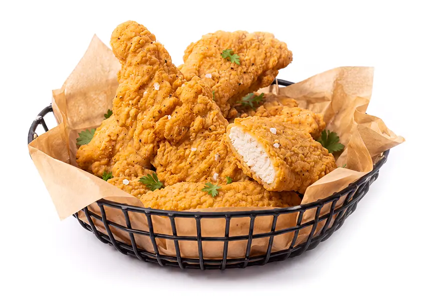 Golden breaded chicken tenders in a paper-lined wire basket, with one tender sliced open to show the white meat inside.