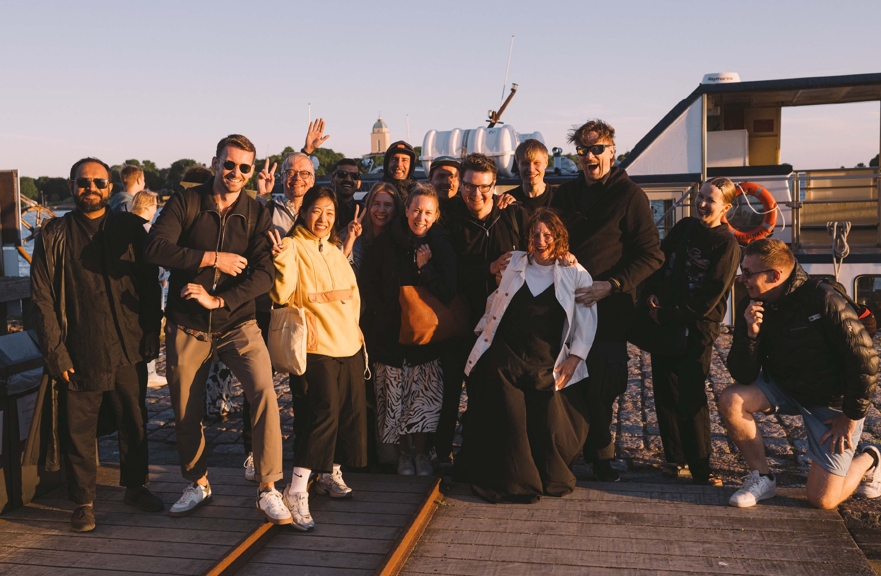 Black and white image of people working at a table with laptops, showing hands gesturing during discussion of digital content displayed on screens, with fabrica® logo in the corner.