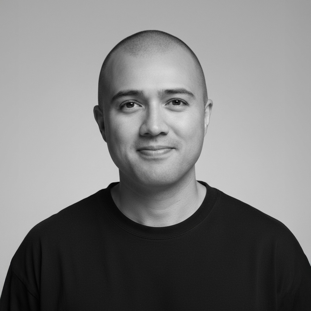 A grayscale professional portrait of Ozan Korkut, posing against a neutral background; the expression is friendly and approachable.