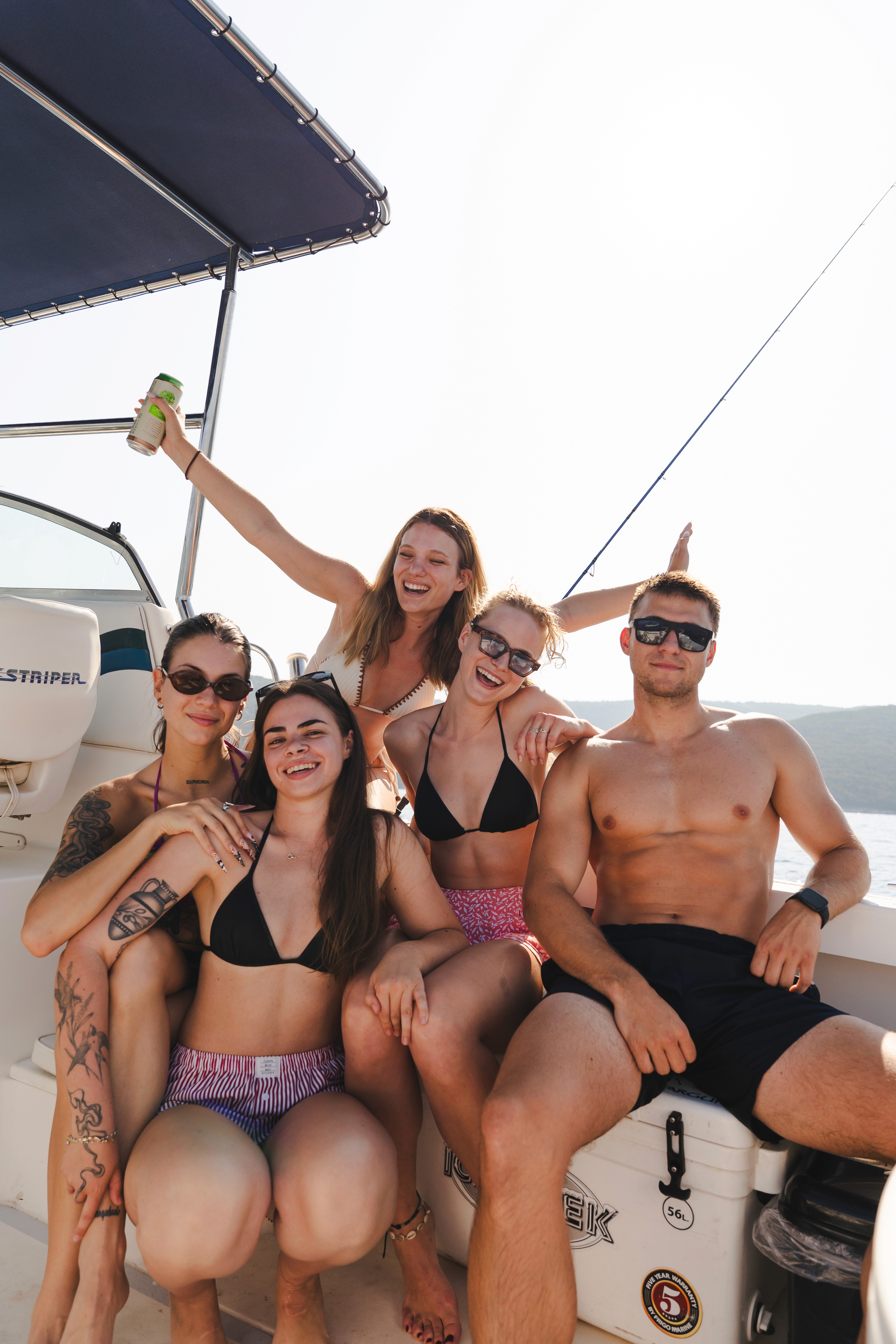 Group of young friends having fun during a boat trip on the Adriatic Sea, enjoying a sunny day on a speedboat.