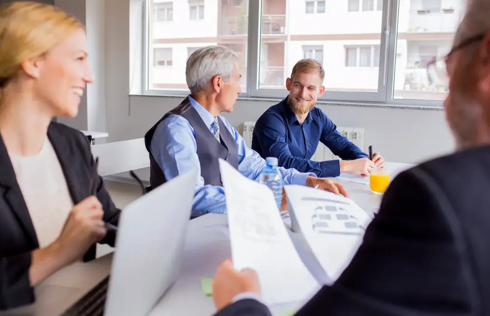Mehrere Geschäftsleute sitzen in einem modernen Besprechungsraum und führen ein professionelles Gespräch.