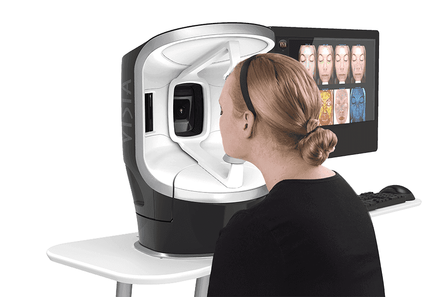 Woman undergoing VISIA Skin Analysis with advanced imaging device that captures high-resolution facial scans to evaluate skin texture, pigmentation, and underlying concerns.