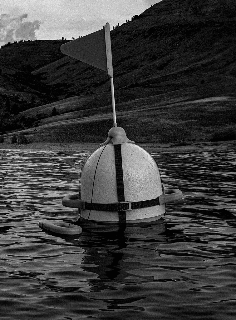 Conceptual rendering of the 'Rescue Buoy,' a safety device designed to assist swimmers in distress. The device is shown floating in the water, highlighting its hoistable flag and ergonomic handles for rest and stabilization.
