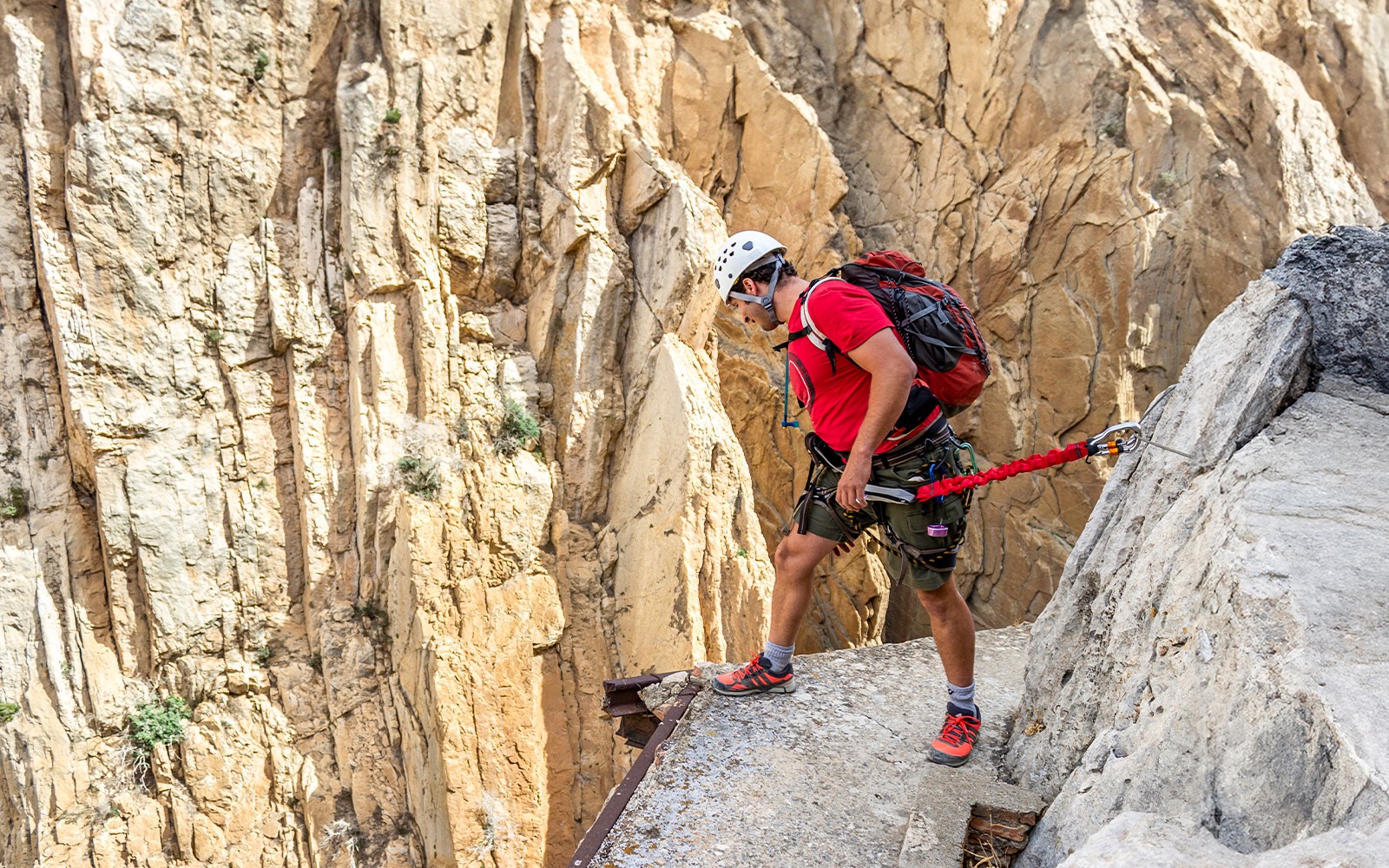 Man rappelling down Caminito del Rey in safety gear, Spain.