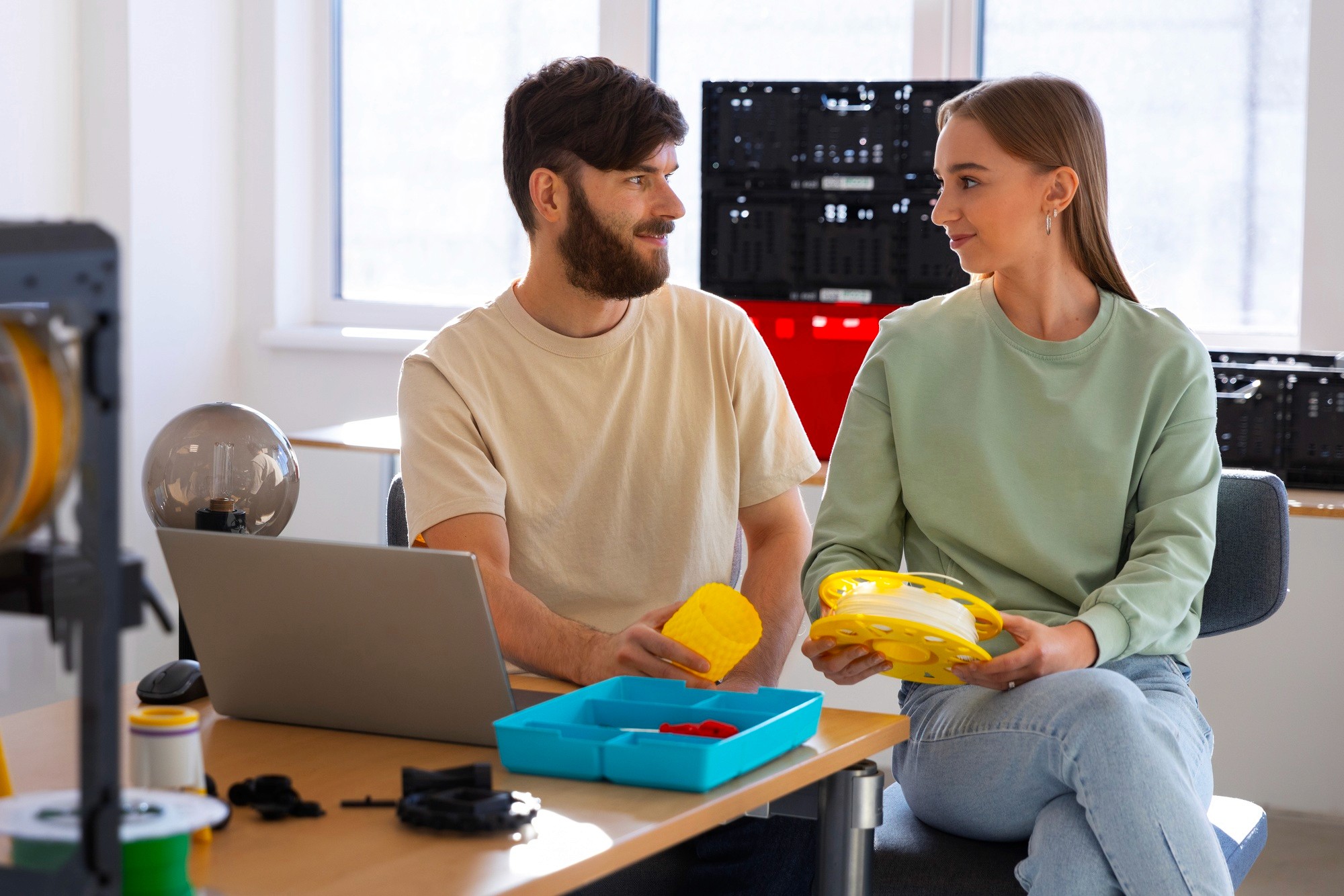 Two content creators recording a product review video with a camera and laptop