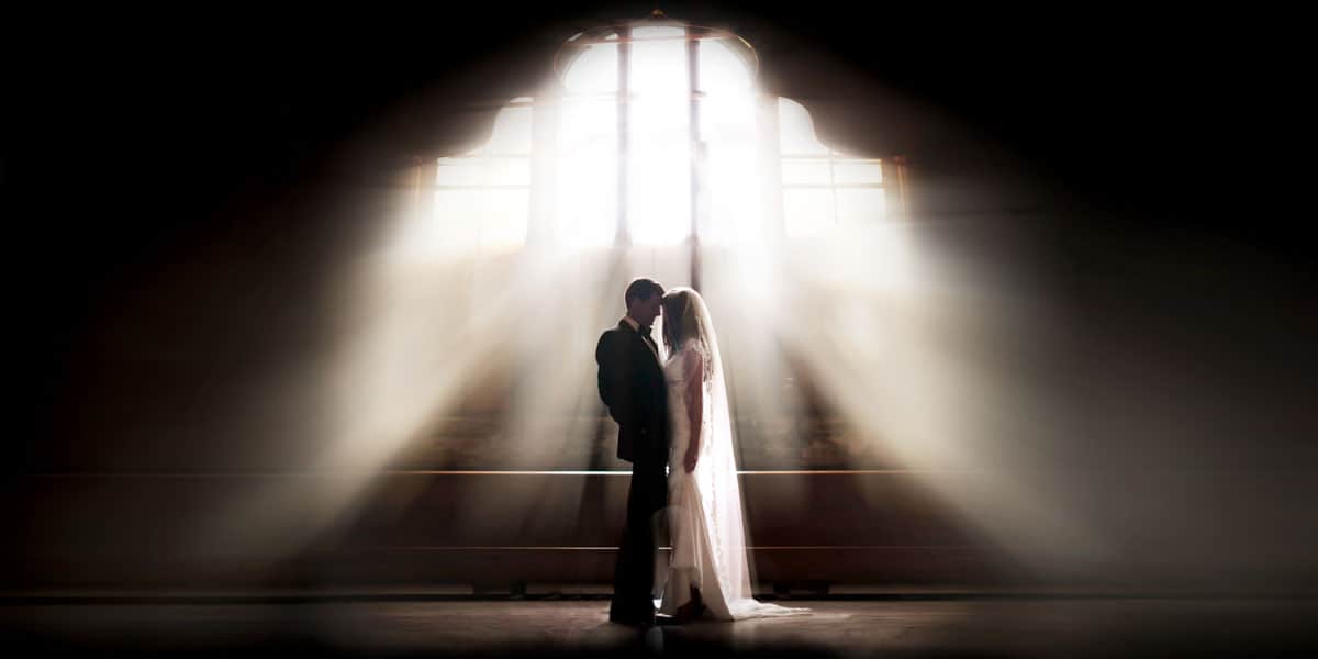 Couple standing together in dramatic light during a cinematic destination wedding moment