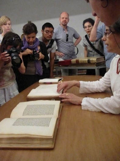 A group of students taking photos of some old books.