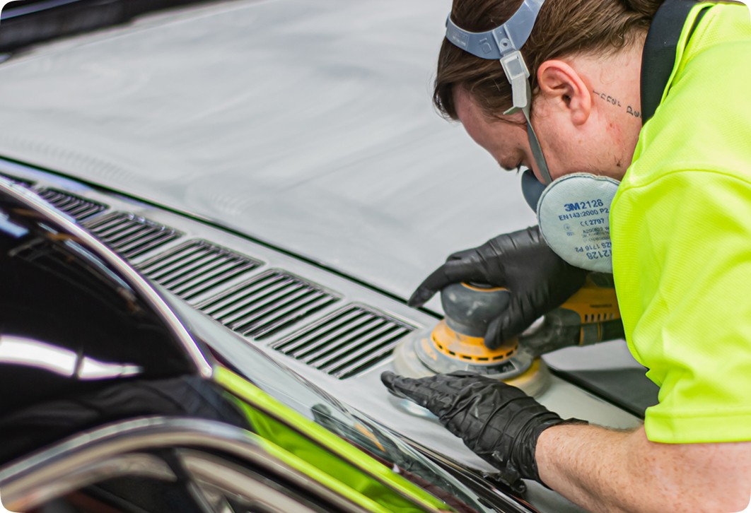 Car detailing: person uses orbital sander