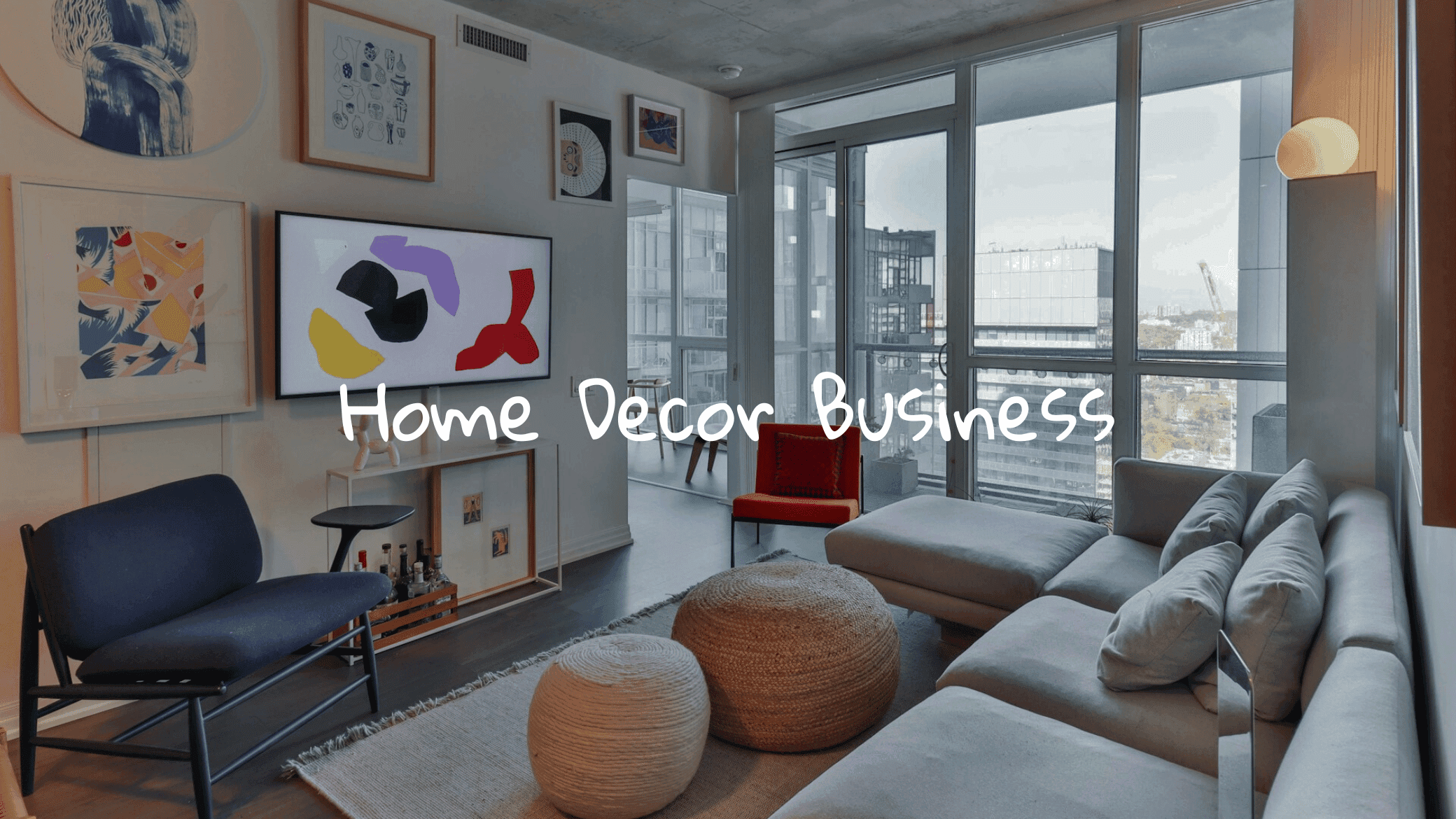 A modern living room with a large window overlooking a city skyline. The room is decorated with a mix of colorful art pieces, a flat-screen TV, and a comfortable seating arrangement with a grey sectional sofa, a red armchair, and several ottomans. The text "Home Decor Business" is handwritten across the image.