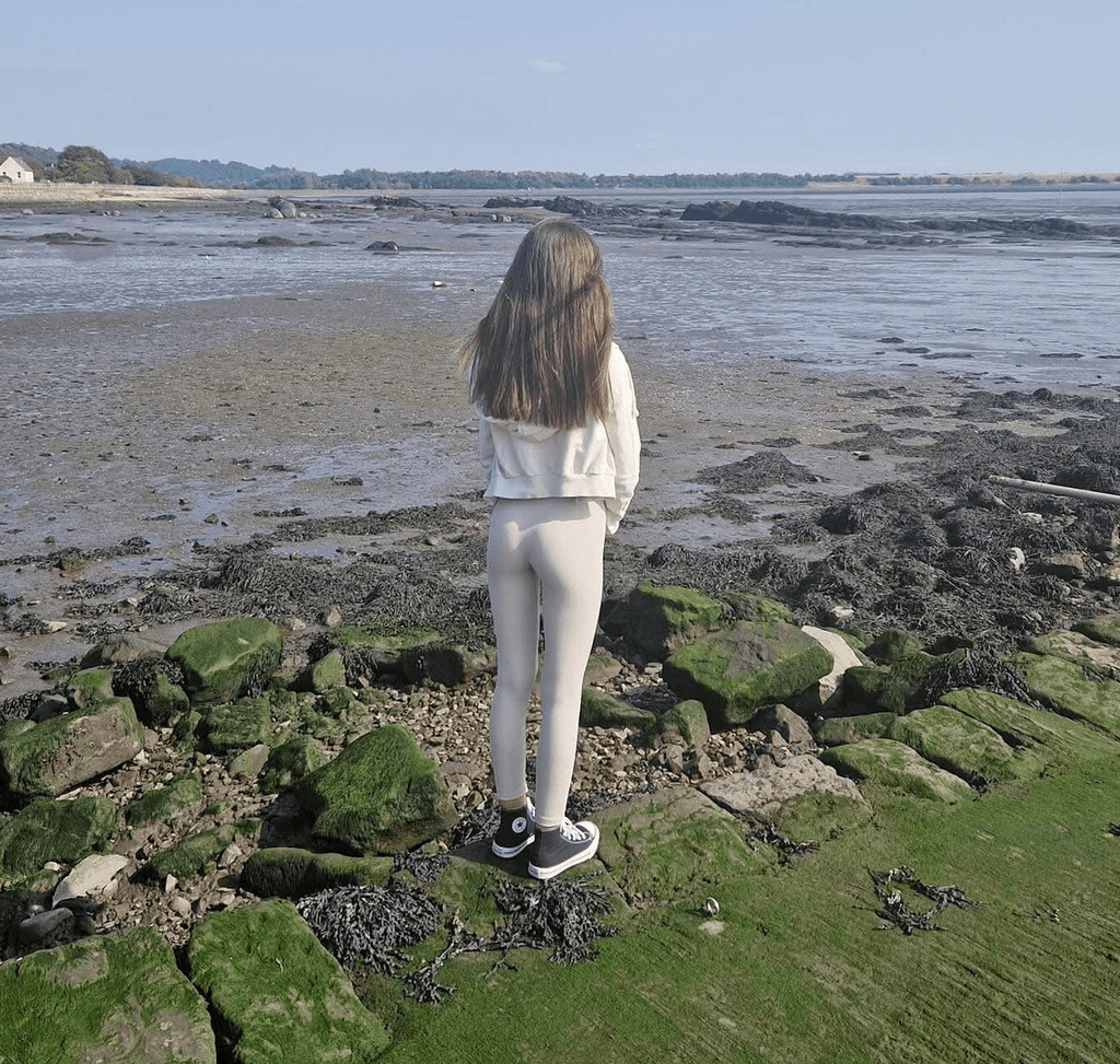 A girl standing by herself looking of into the distance