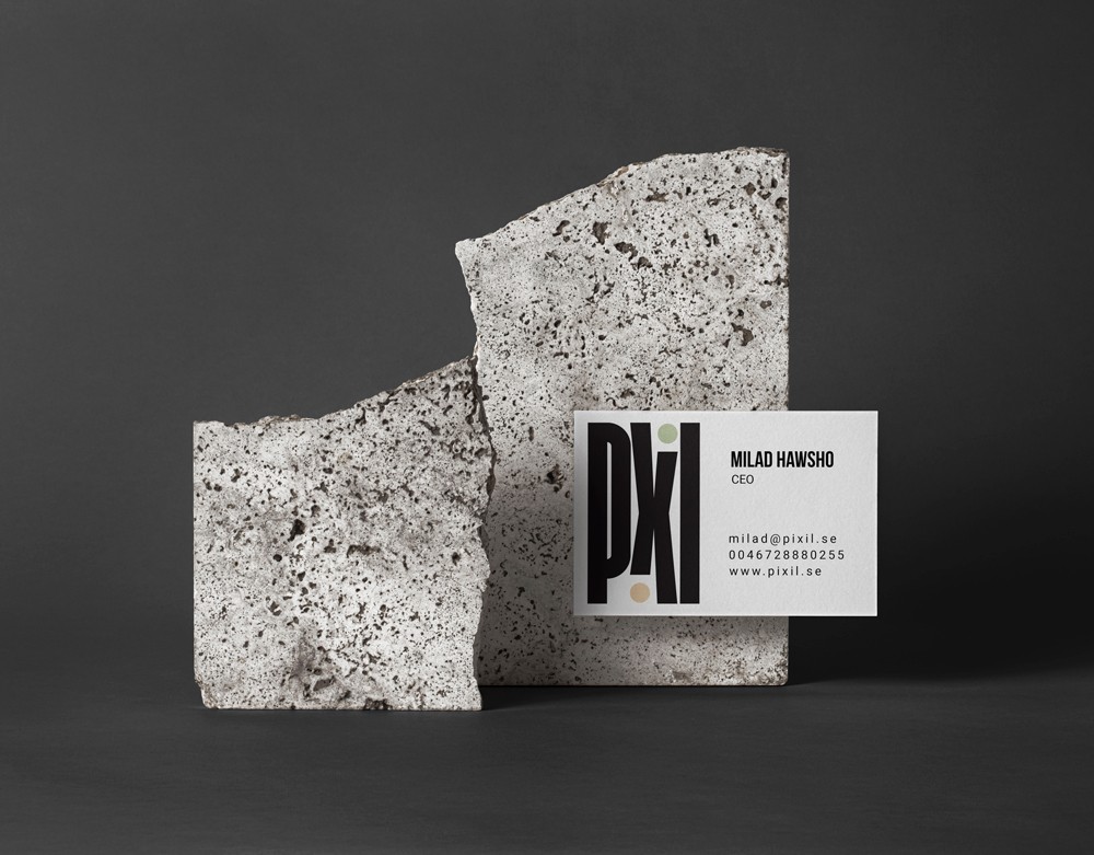Pixil branded business card and booklet sandwiched between two rough granite stone slabs, used as a project thumbnail for OUF Studio's case study.