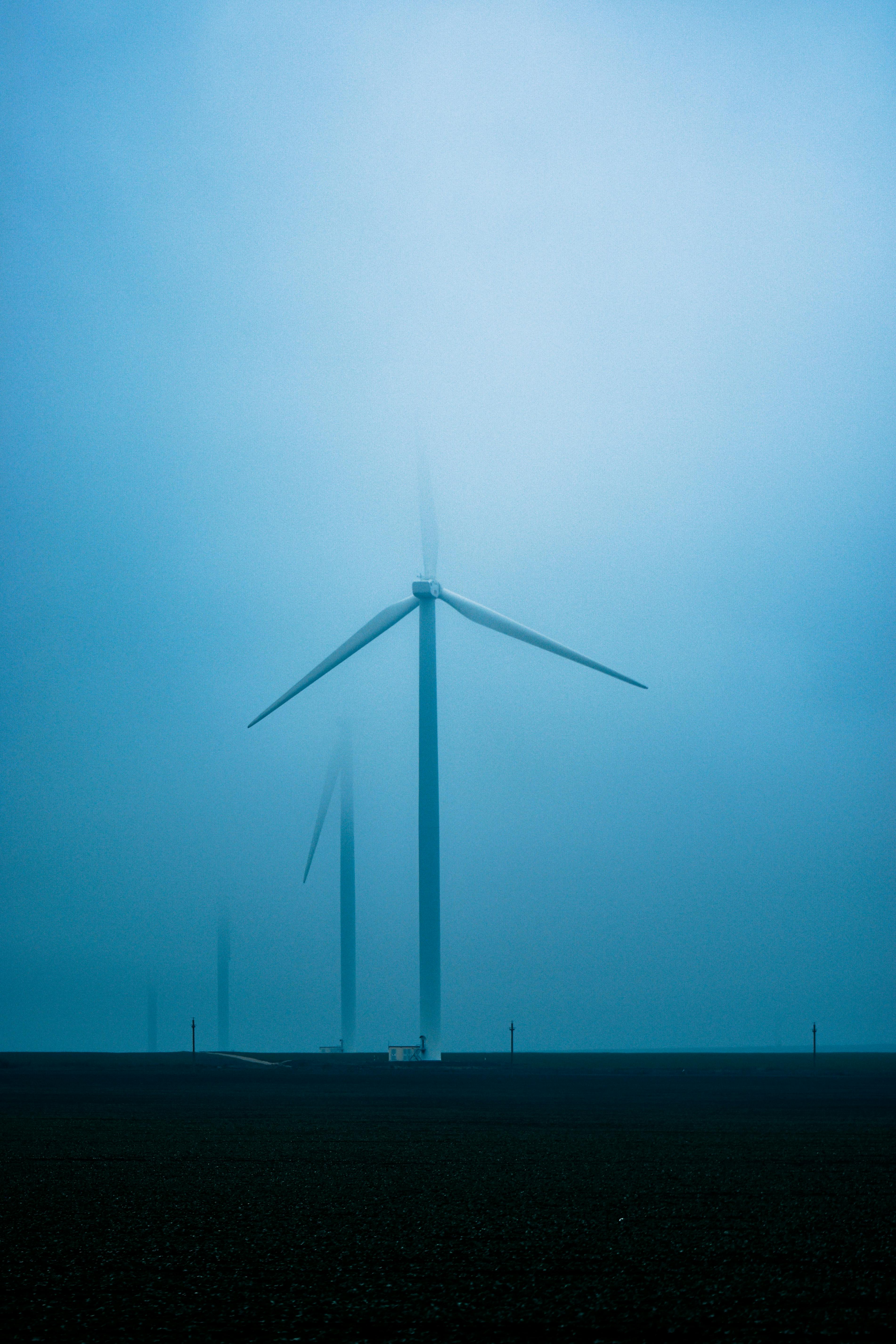 a car driving down a highway next to a bunch of windmills