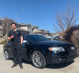 Happy customer holding a newly programmed Audi car key made by CarKeyAction in Calgary.
