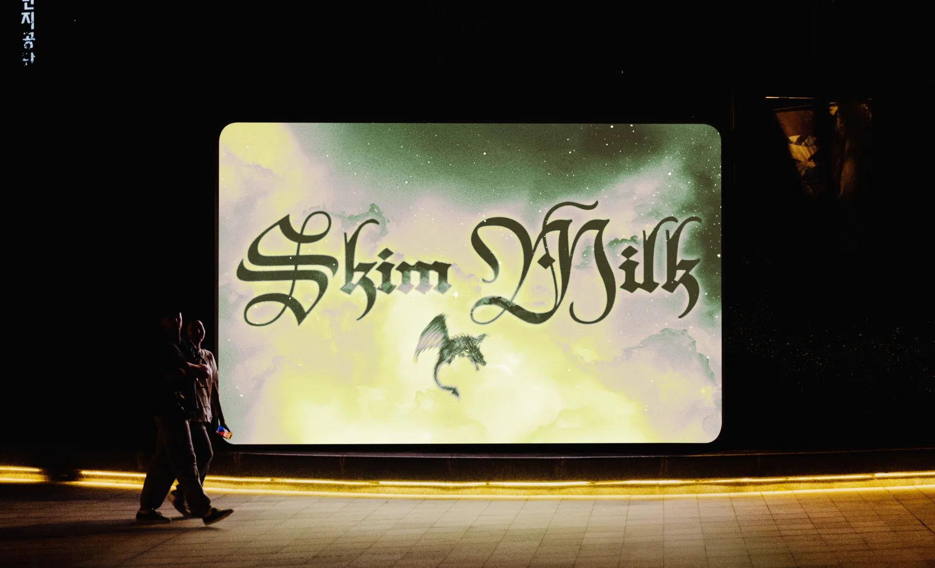 People walking past a screen with a powerpoint slide from the 2026 Annual CSU Drag Show, for the performer Skim Milk