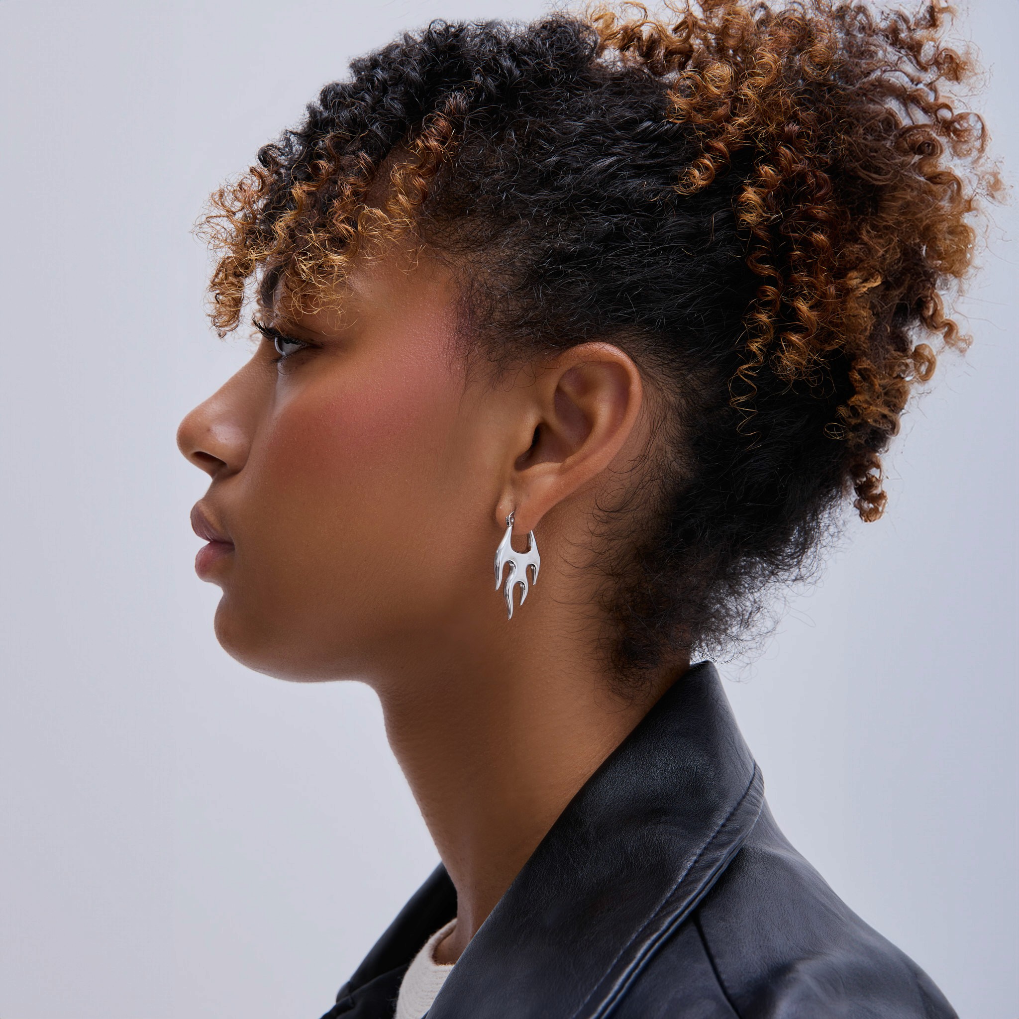 Young woman with dark hair and bangs, wearing red.