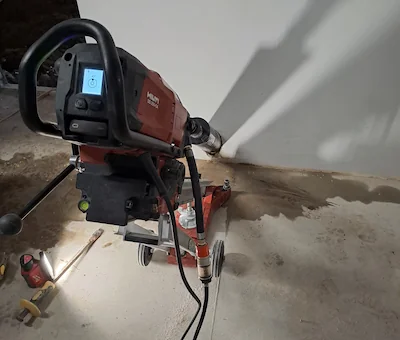 Detailní záběr na proces jádrového vrtání do zdiva.
