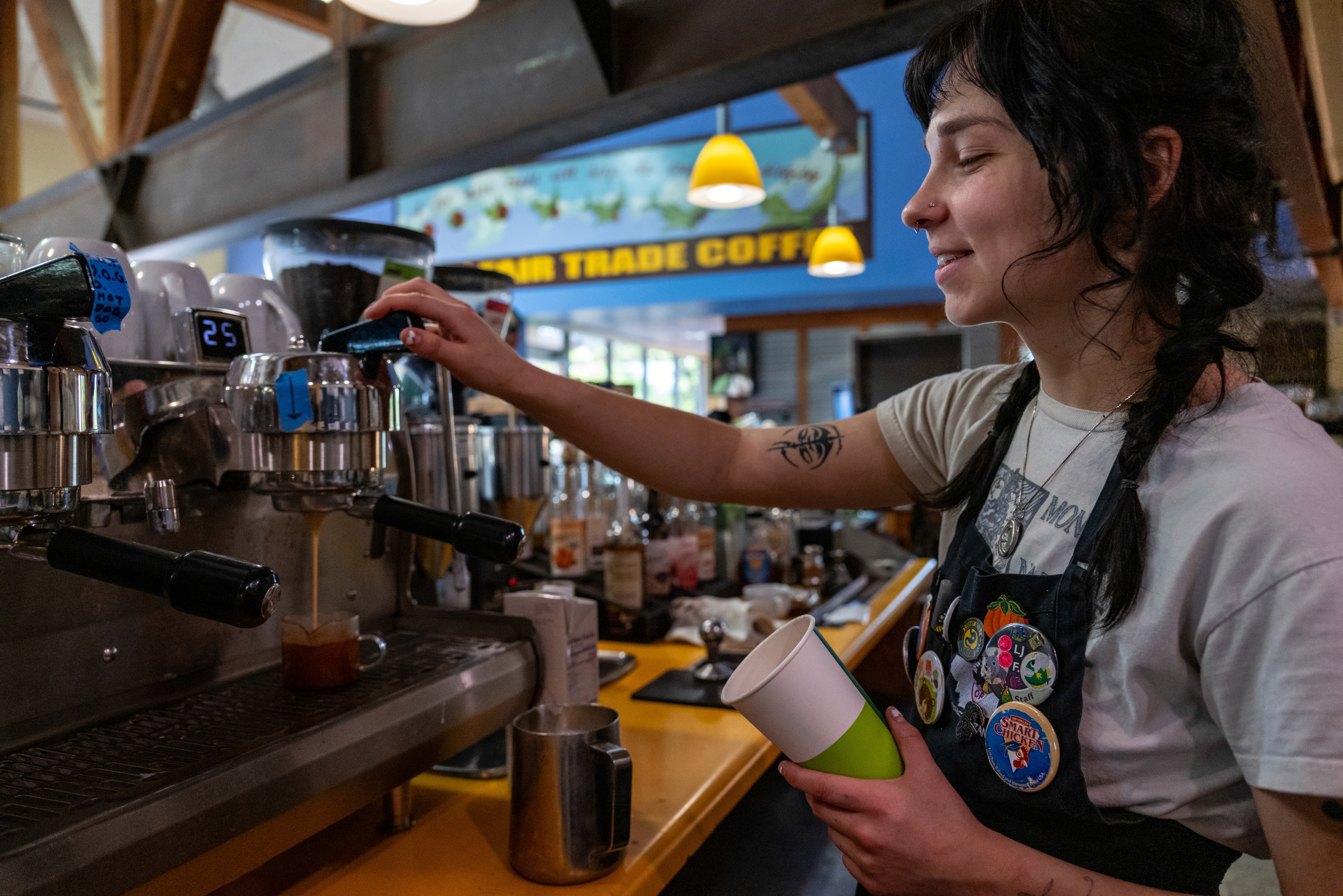 A person sitting at a bar counter, smiling, holding a drink, with a warm, inviting interior in the background.