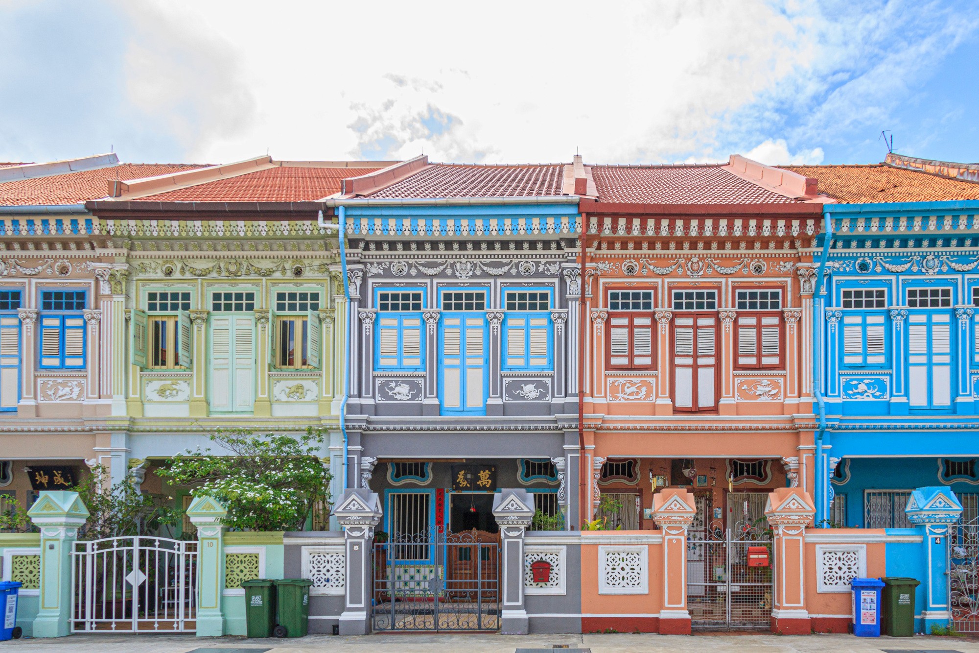 a street lined with stone buildings next to a lush green forest