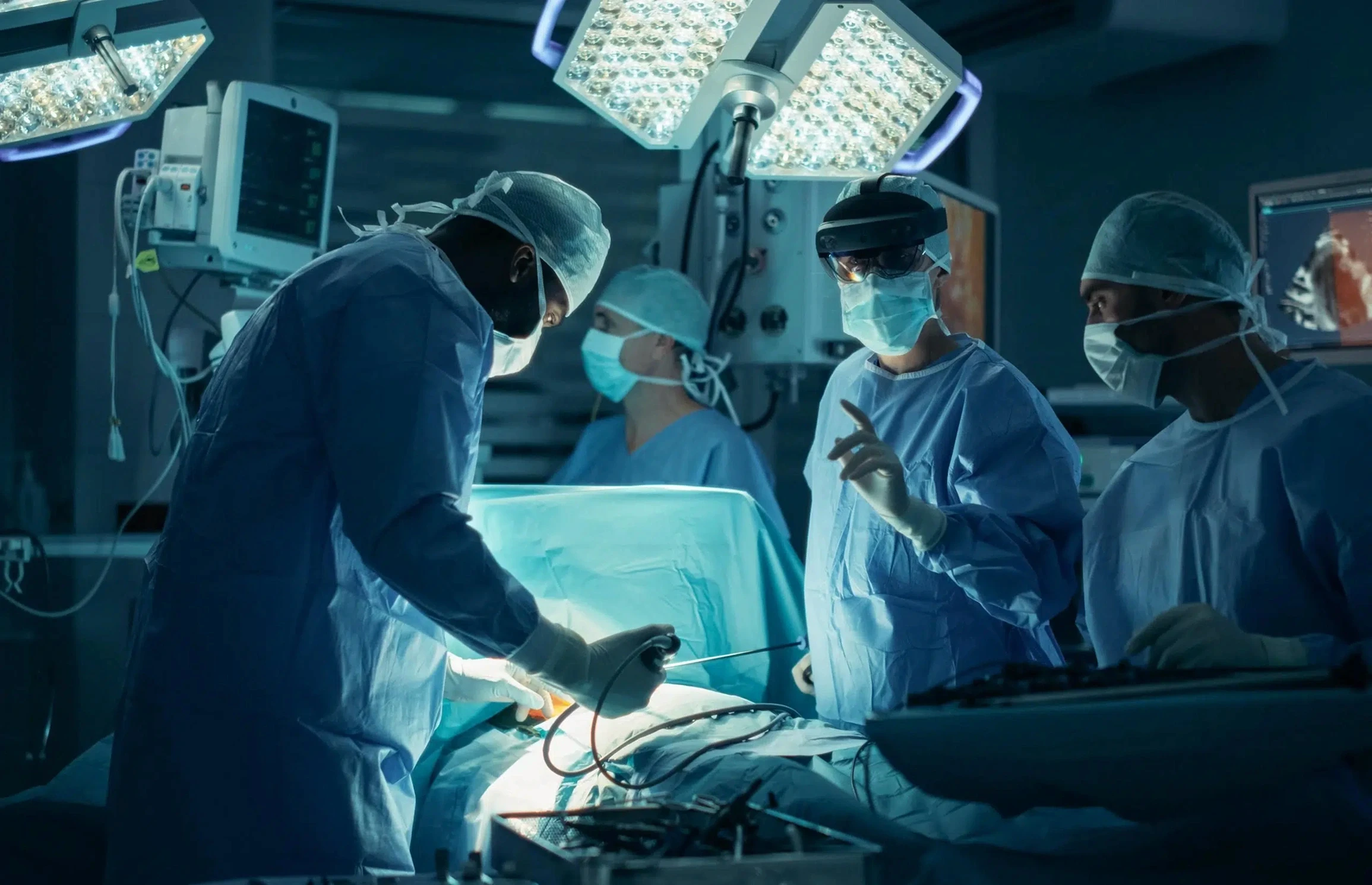 Surgical team performing a minimally invasive procedure with the lead surgeon wearing an augmented reality headset, demonstrating AR-assisted intraoperative guidance in clinical use.