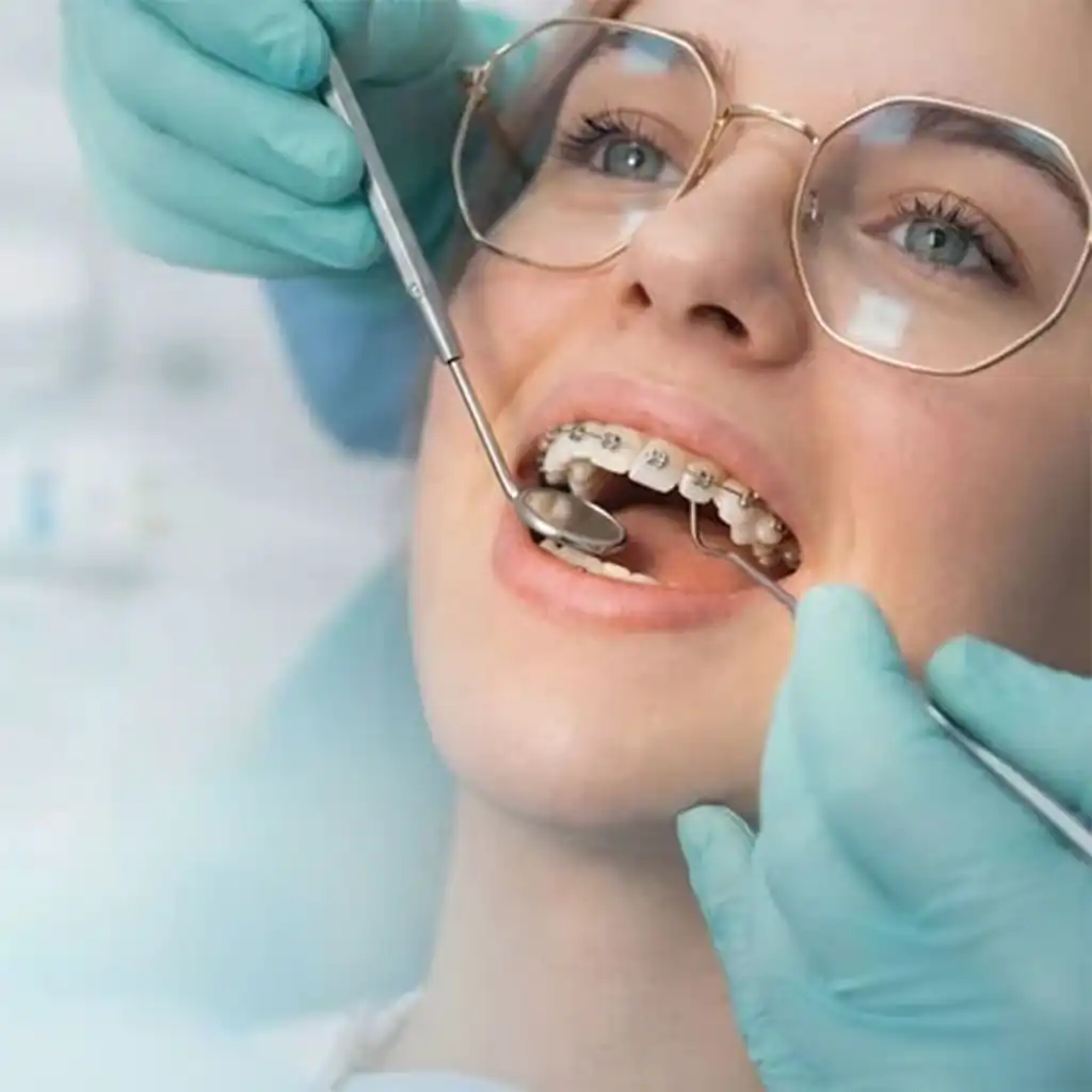 Dental professional in black gloves performing procedure with drill and mirror on patient in clinic
