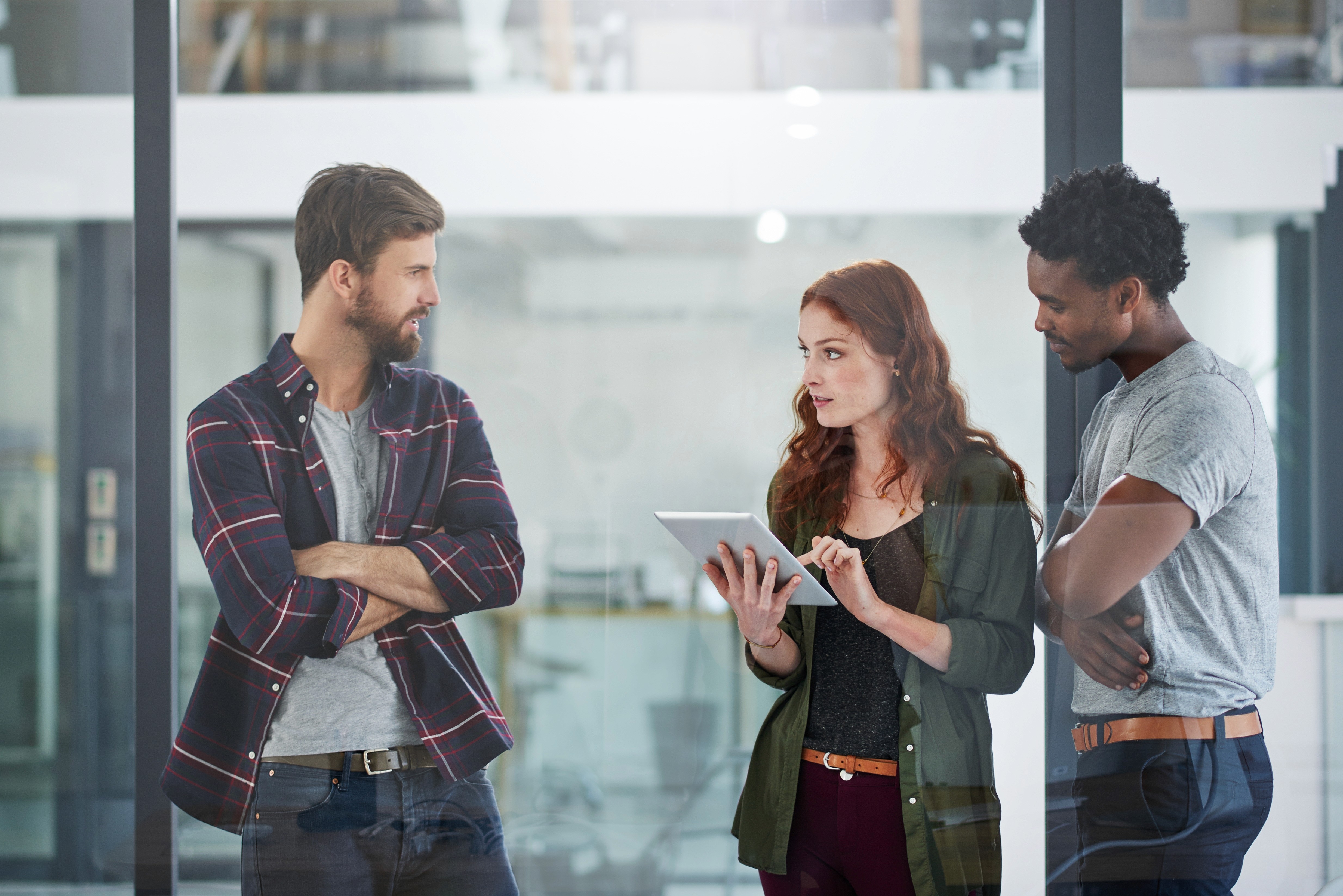 Image of a team collabrating on a tablet in a modern office.