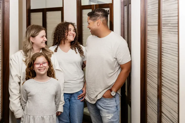 Family photo with Mother, Father, and two daughters all smiling at ScarboroSmiles : Best dentist in Scarborough, Ontario