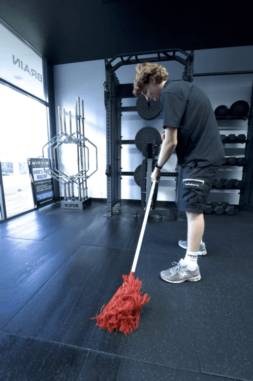 Cleaner mopping the floor of a Perth gym as part of a commercial cleaning service