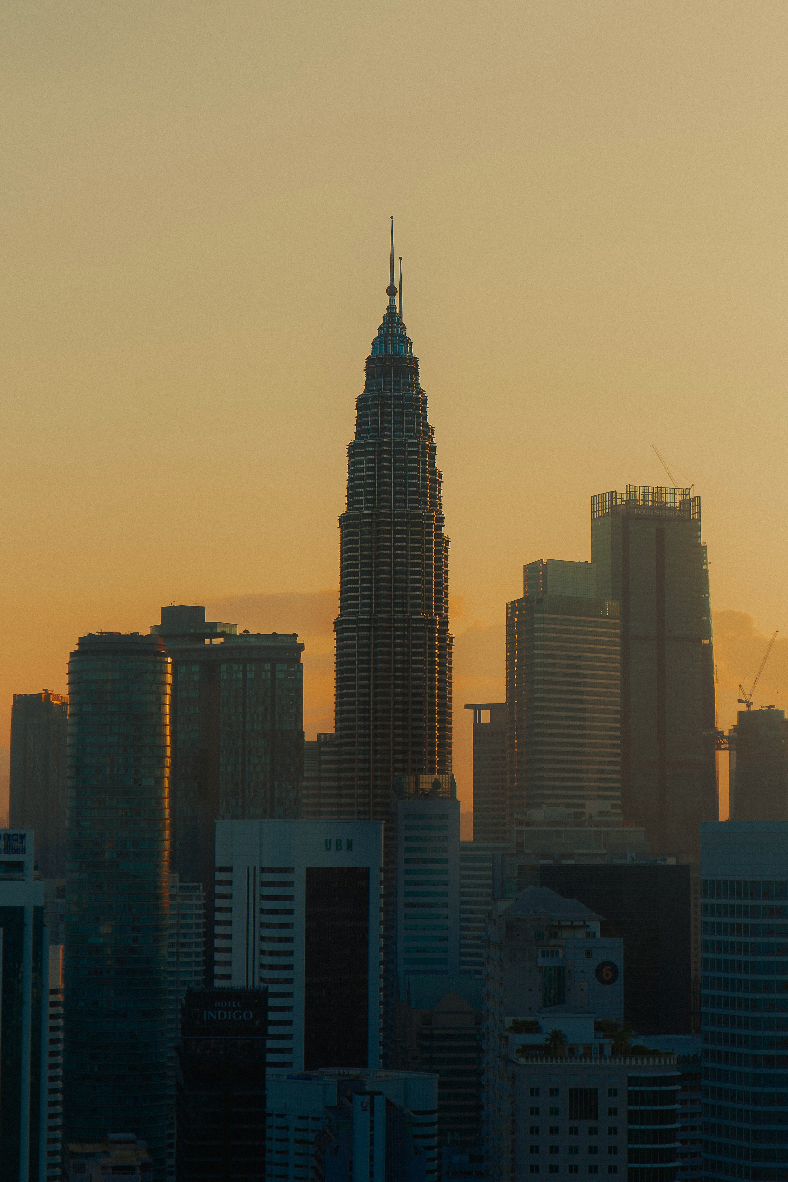 Skyscrapers silhouetted against an orange sunset.