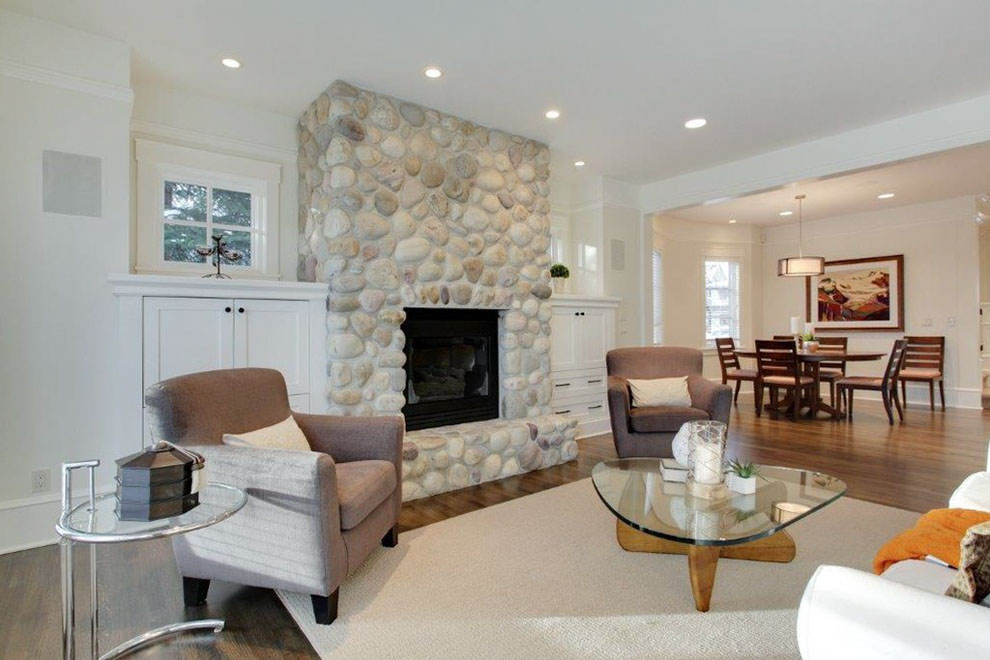 Image of Luxury living room interior design with stone fireplace, furniture, and layout design by KHD Homes.