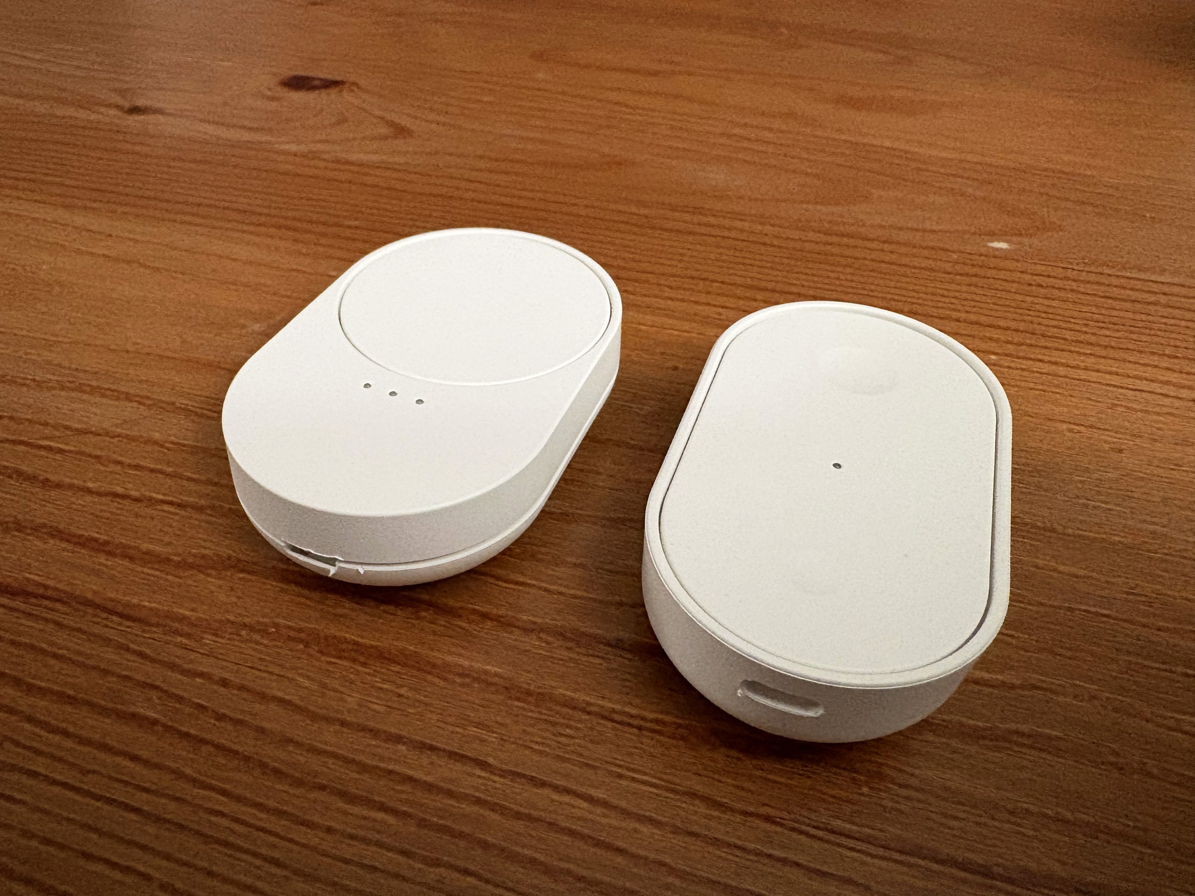 Two sleek, white wireless charging pads are positioned on a wooden table, showcasing a minimalist design ideal for efficient and modern energy solutions; BILRESA.