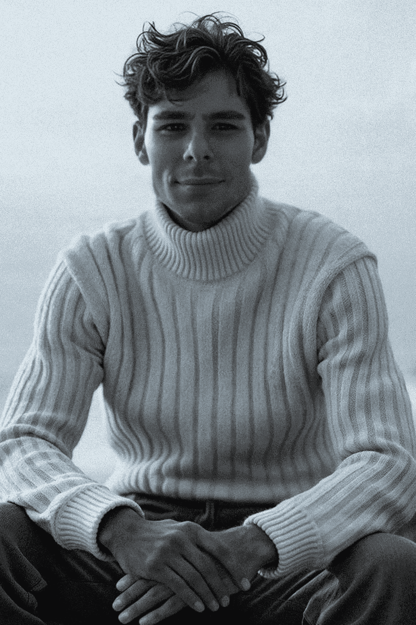Profile portrait of a man in a white shirt against a light background