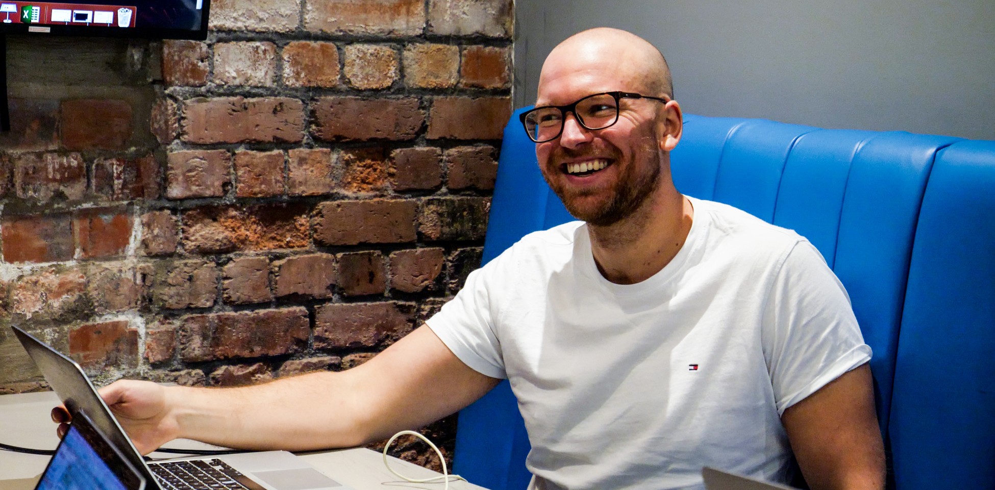 A person sitting at a table with laptops.