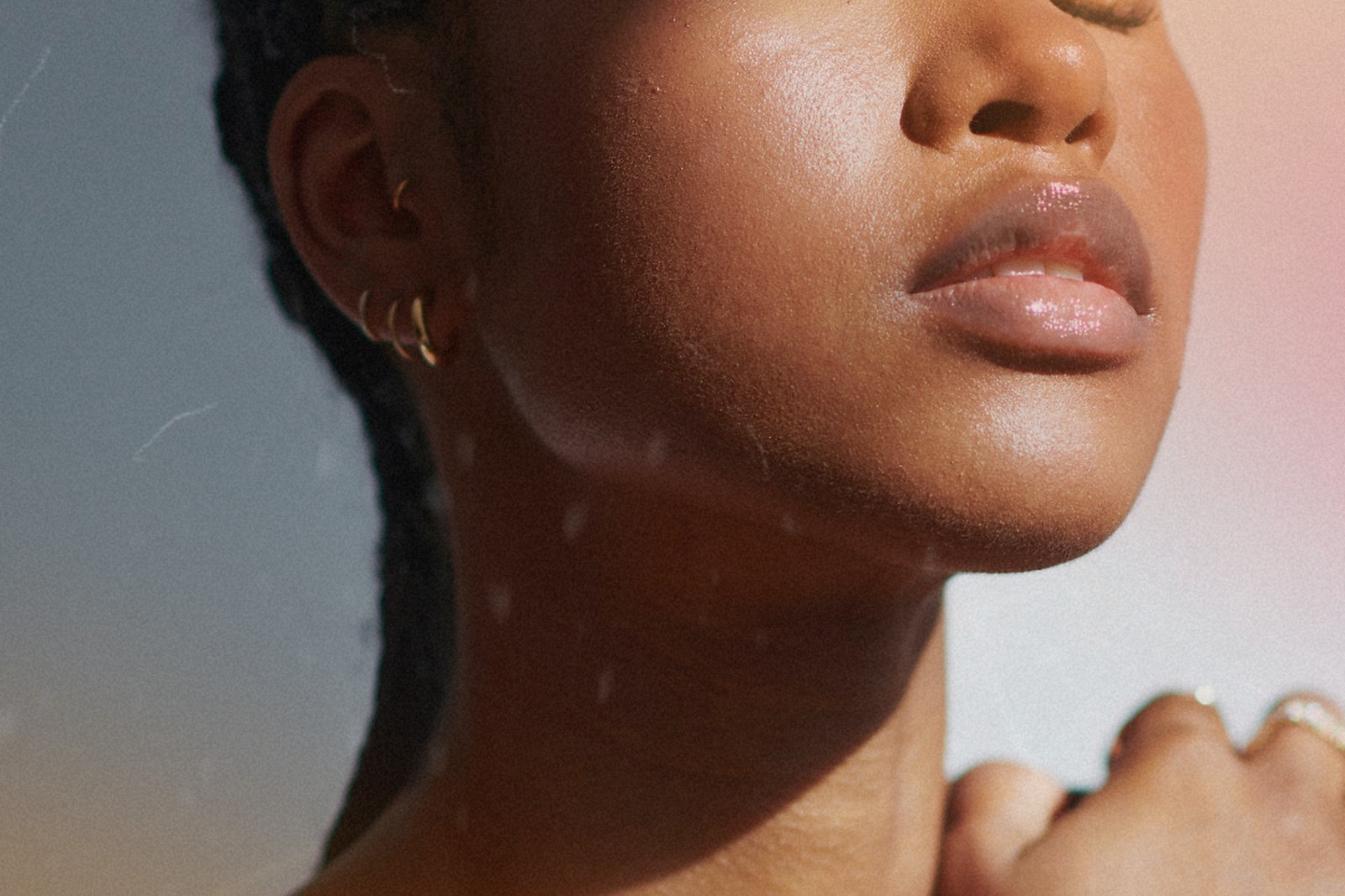 Close up of a woman's face, neck and shoulder in soft daylight.