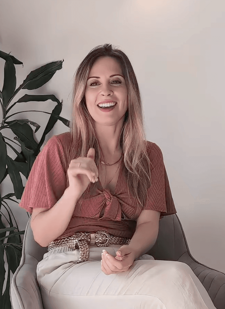 Chloe O’Brien seated in an armchair, smiling and speaking in a calm, welcoming setting.