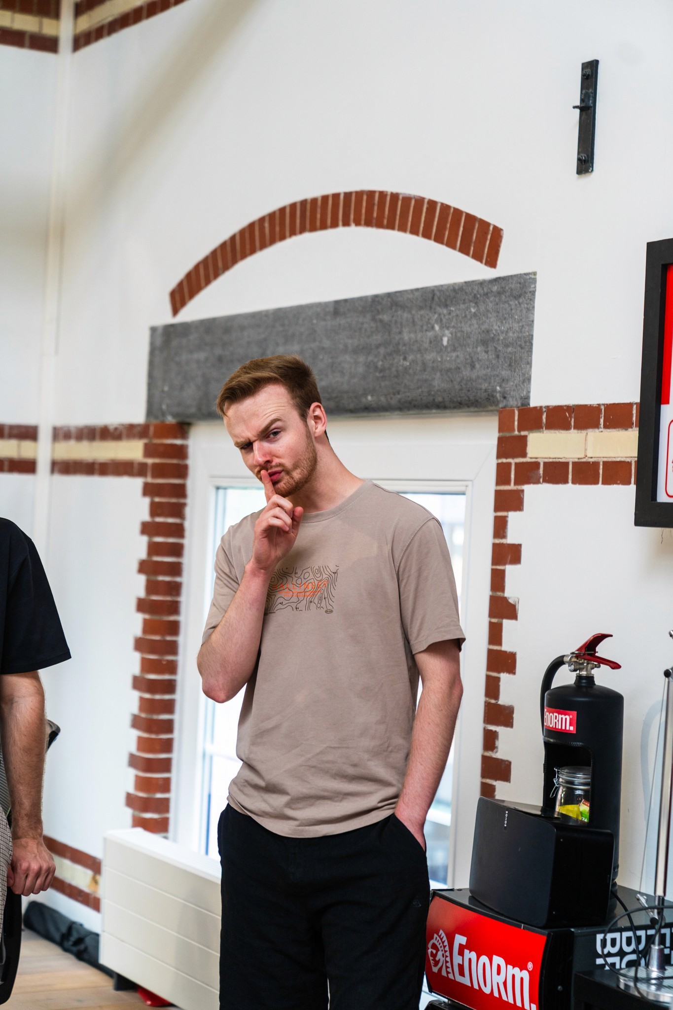 man holds a finger to his mouth telling you to be quiet