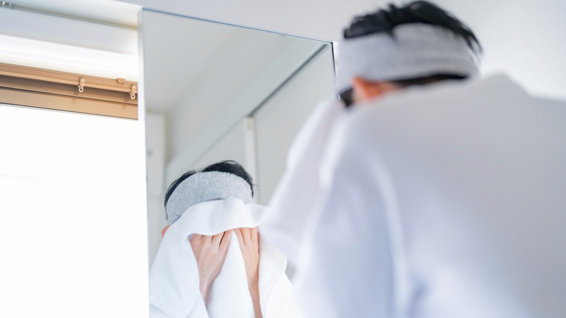 タオルで顔を拭く男性