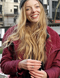 A photo of a girl wearing a red coat and a hat.