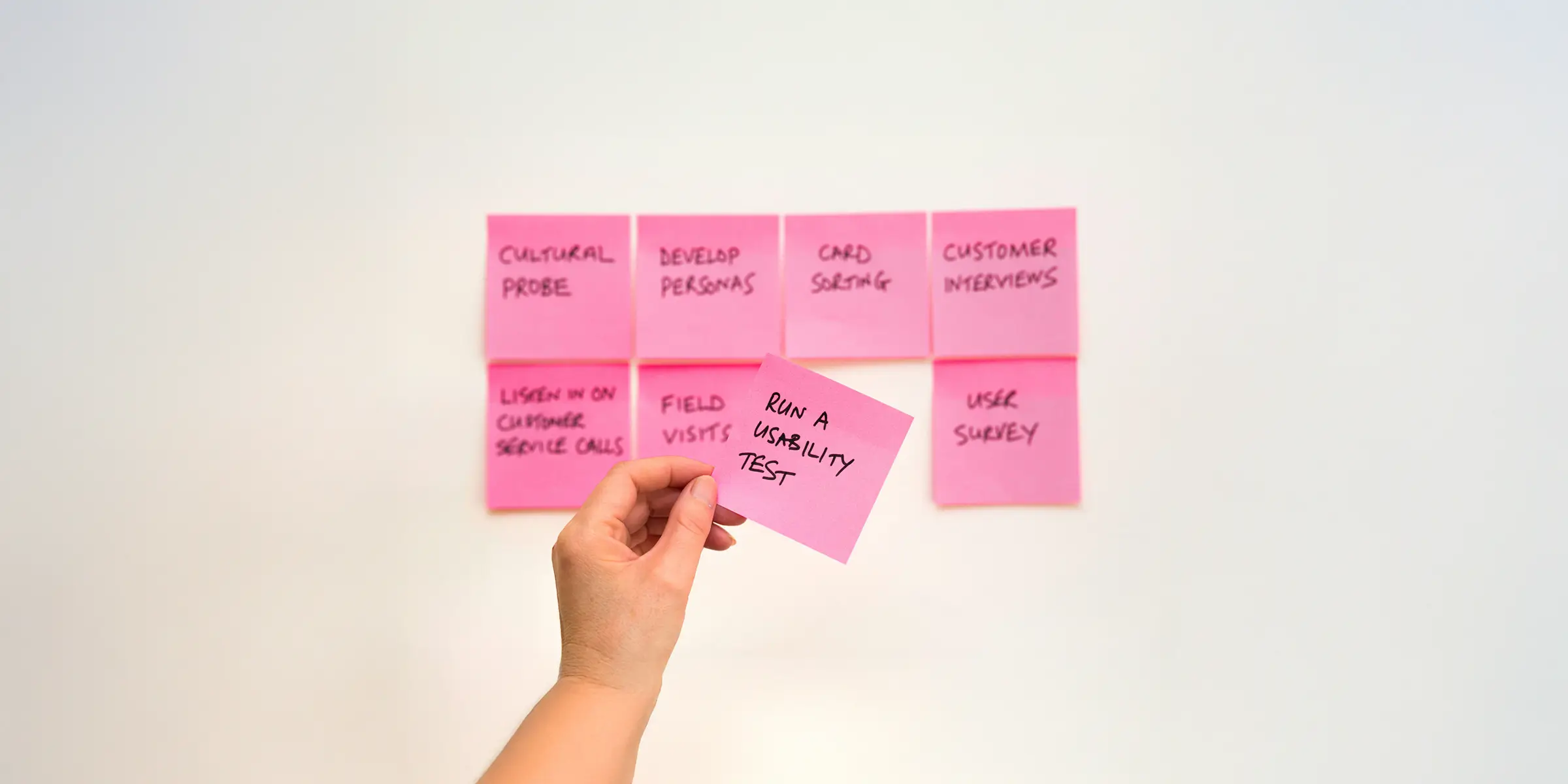 image of post it notes depecting user testing, with the text mainly out of focus but one post it note sharply in focus with the text "run a usability test"