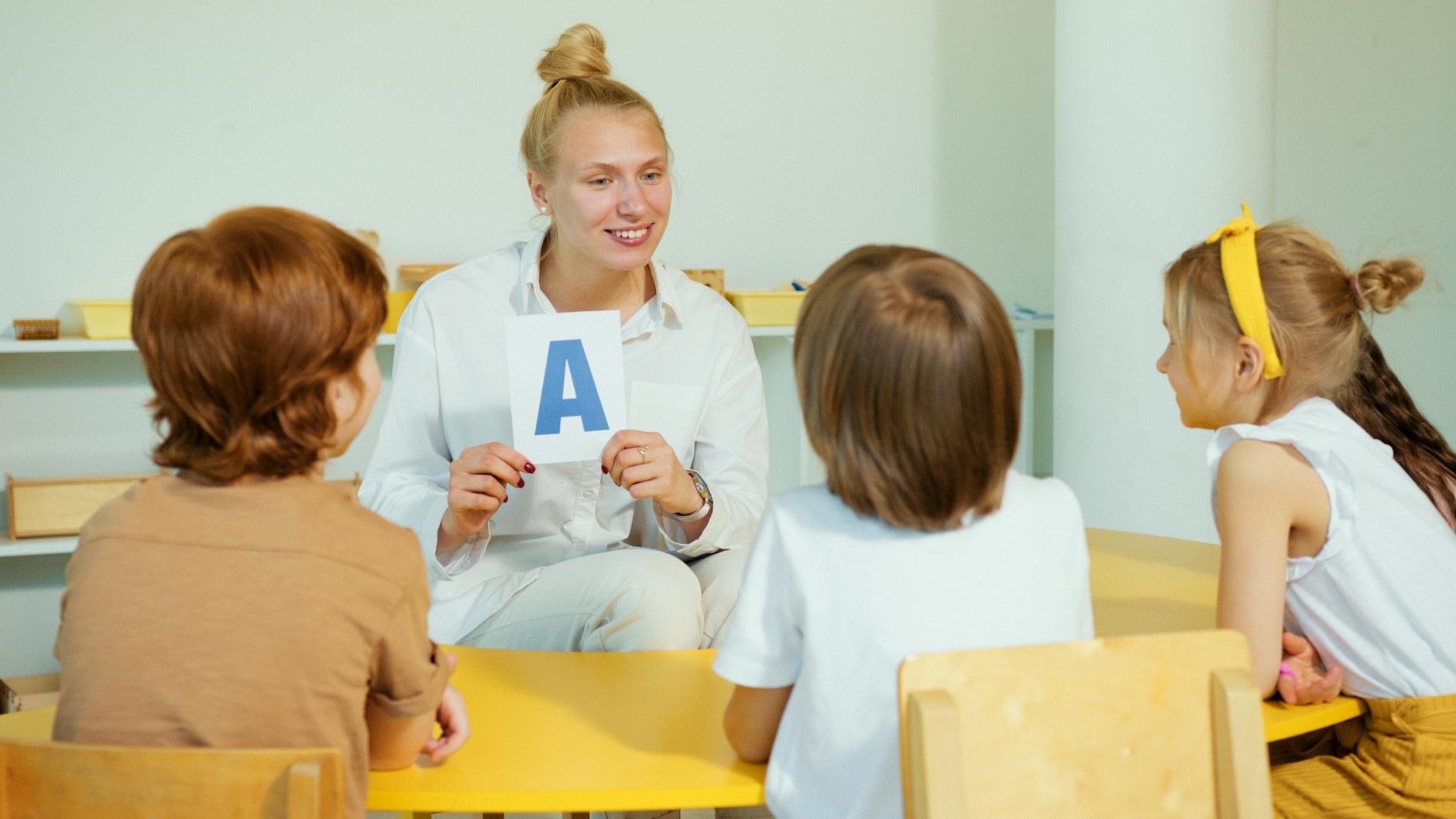 A school counselor sitting in a cozy nook using a storybook to discuss feelings with a small group of students.