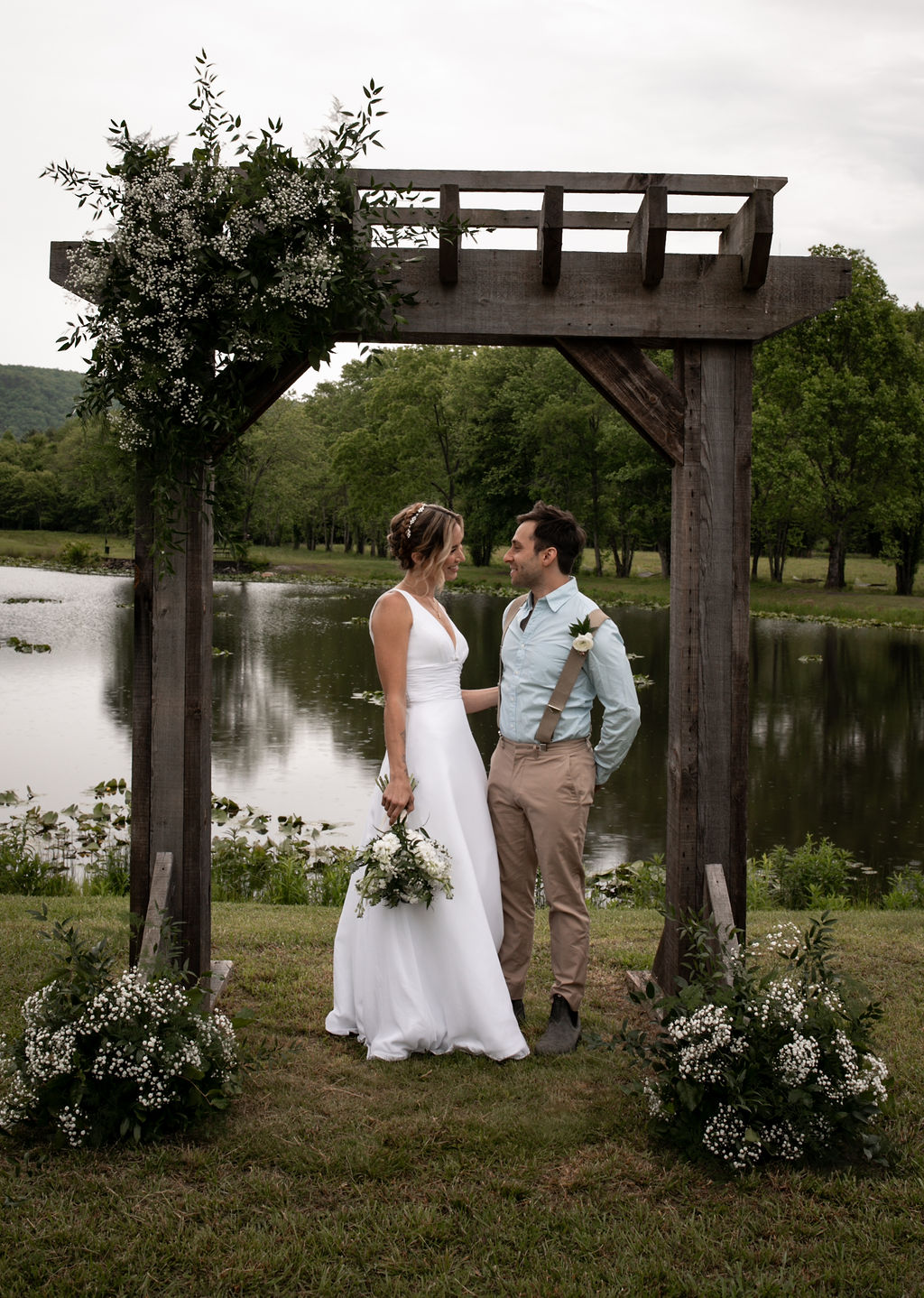 couple embracing one another in front of a lake