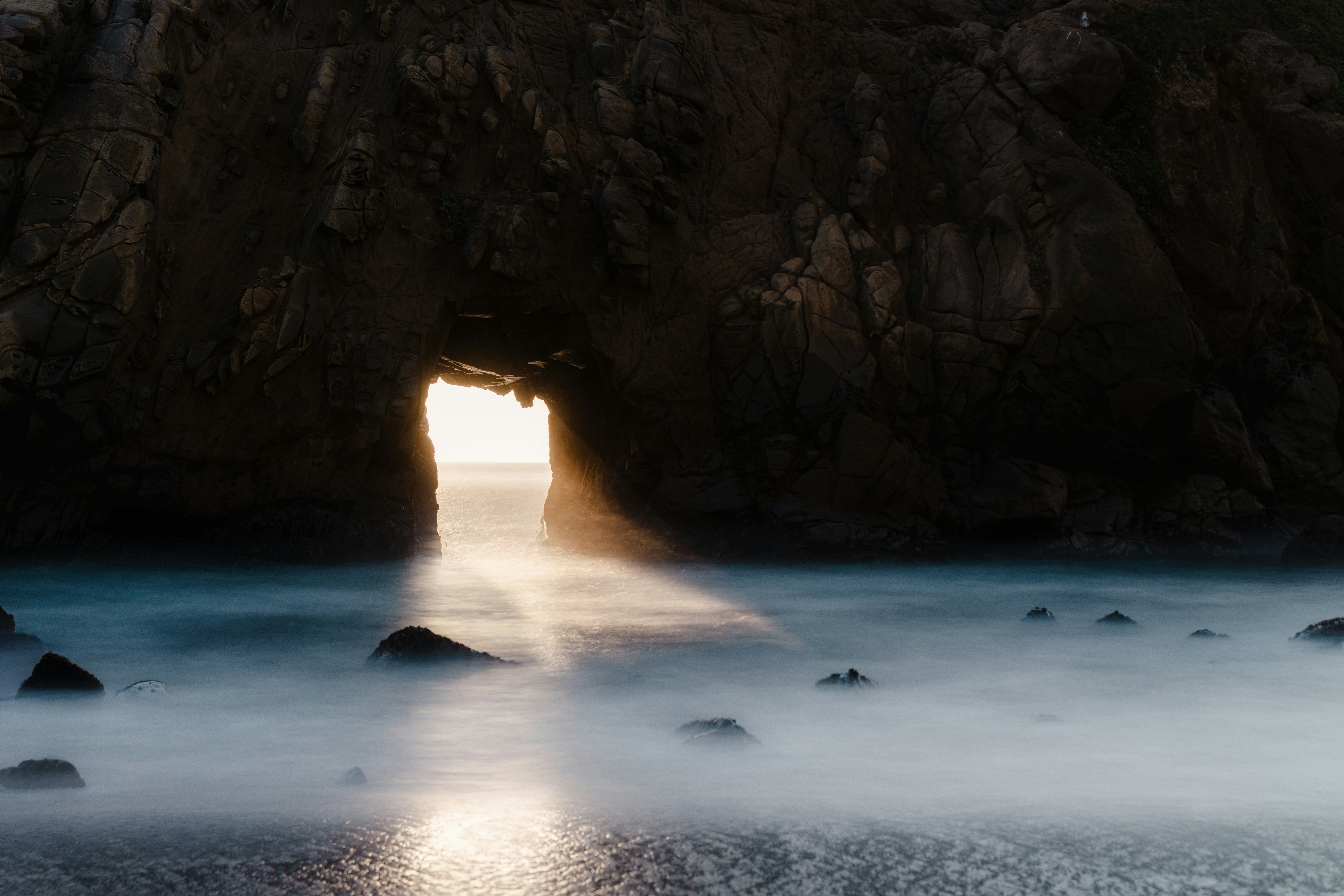 Sunlight streams through a sea cave opening