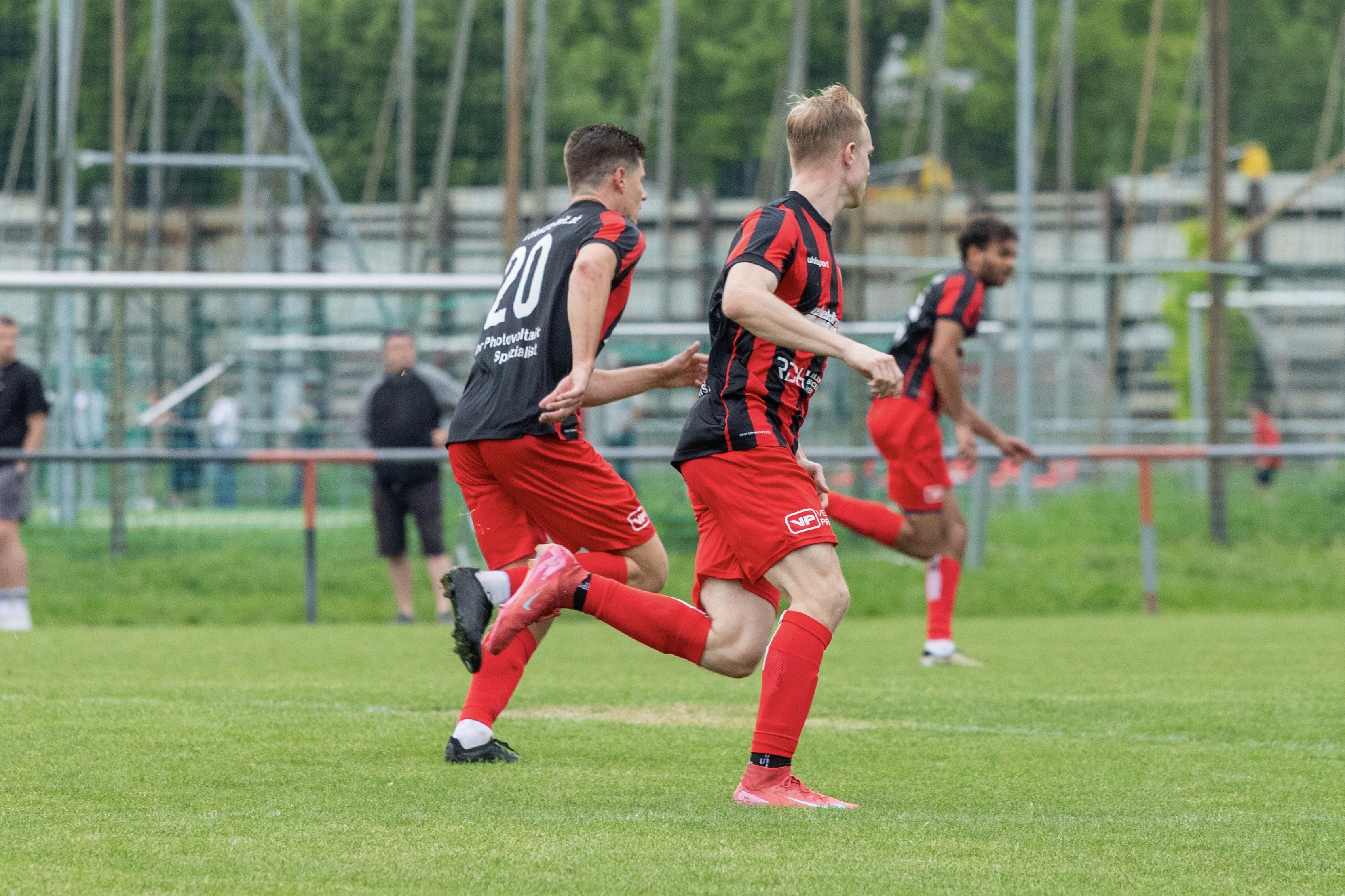 Two players sprint back on the pitch