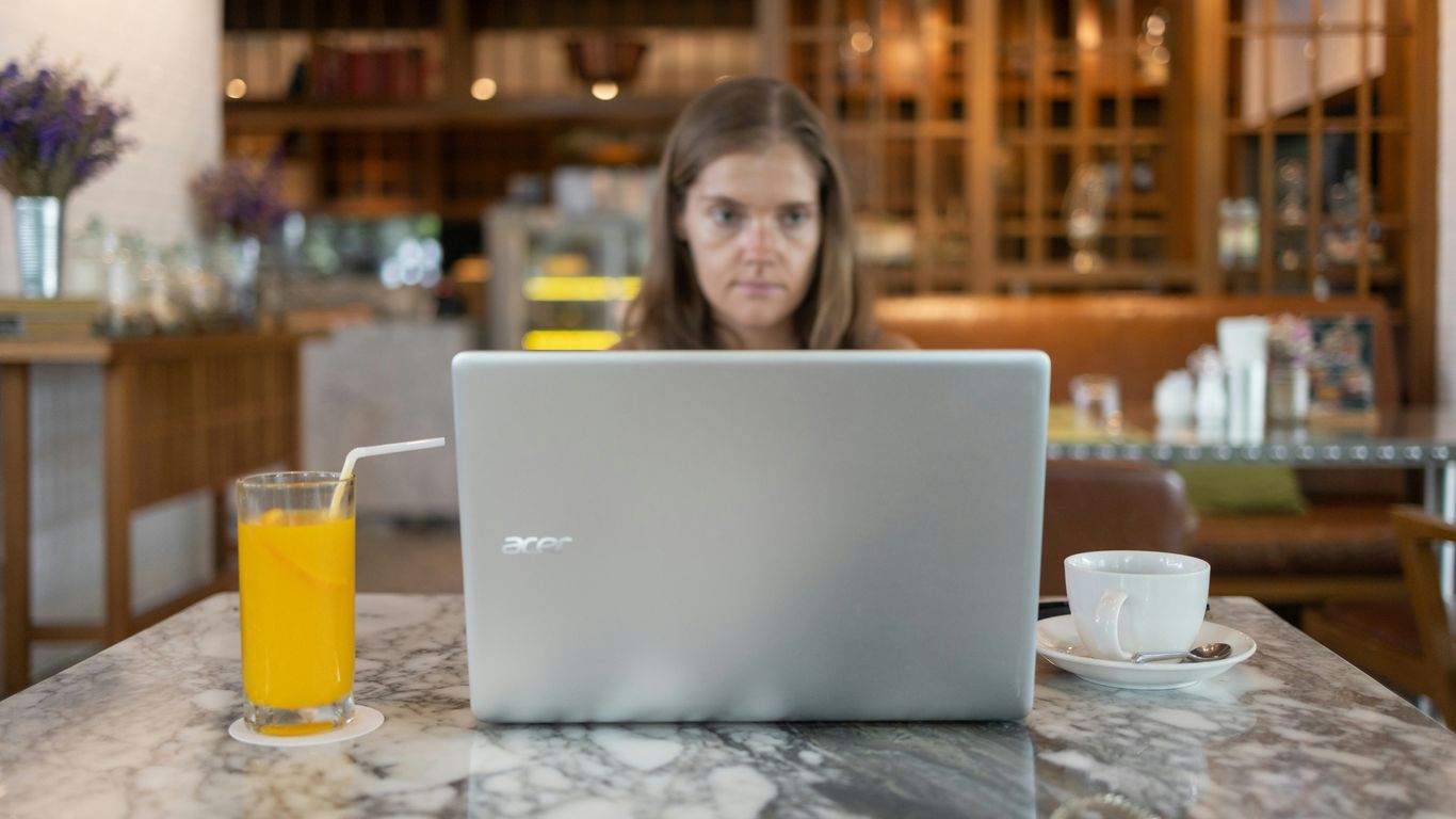 a person sitting at a table with a laptop