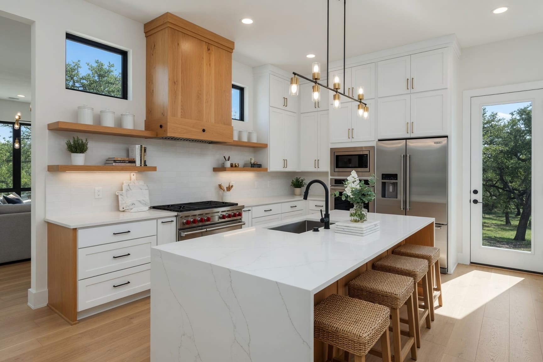 Kitchen with marble island, white cabinetry, and wood open shelving